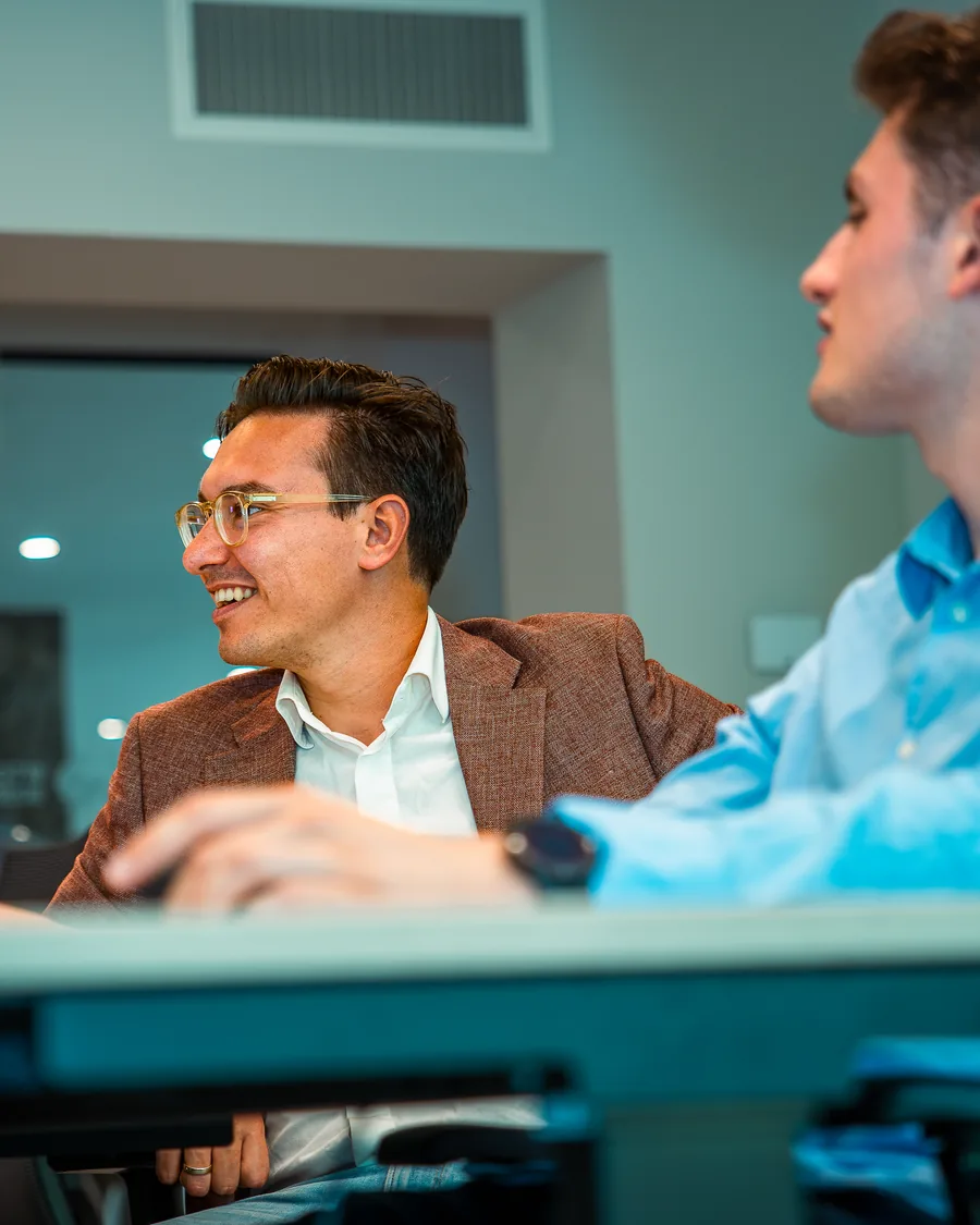 Newbit-consultant typt op een laptop terwijl een collega meekijkt