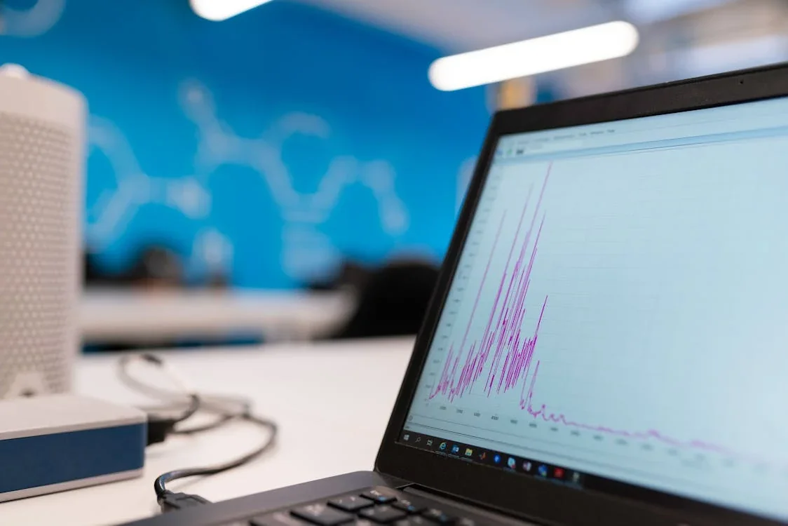 wat is data warehousing: laptop met roze grafiek toont gecentraliseerde data-analyse in modern kantoor