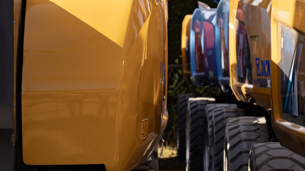 Close-up van een gele graafmachine met op de achtergrond meer gele machines
